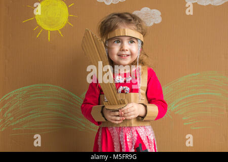 Ritratto di un bambino giocoso con una spada di cartone e un abito stile vintage Foto Stock