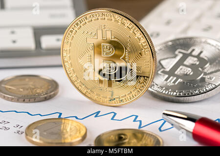 Bitcoin crypto euro cambio valuta concetto finanziario golden argento monete di rame sulla calcolatrice scrivania in legno con tastiera e matita rossa Foto Stock