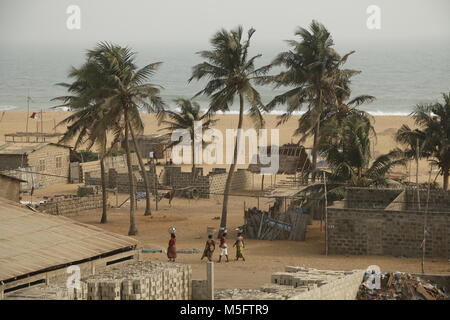 Spiaggia in Benin con palme, ampie spiagge, fishermens case, case sulla spiaggia e barche da pesca Foto Stock