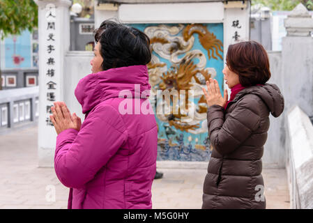 Due donne a pregare nel Thap ma santuario a Ho Lago Hoan Kiem, Hanoi, Vietnam Foto Stock