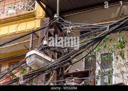 Centinaia di cavi elettrici sono sparsi su un palo elettrico in un modo pericoloso di Hanoi, Vietnam. Questo è lo standard di distribuzione della potenza in tutta la penisola indocinese. Foto Stock