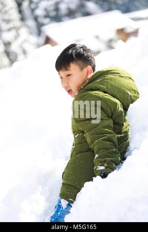 Ragazzo stabiliscono sulla neve e godere la neve in inverno Foto Stock