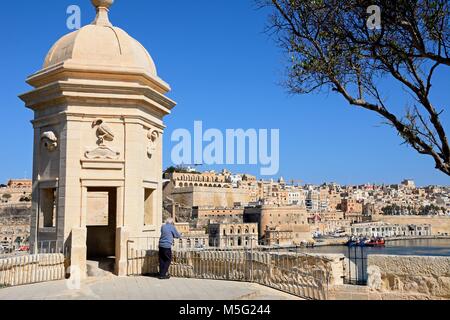 Uomo che guarda la vista verso La Valletta da un bastione nel Gardjola Gardens, Senglea, Malta, l'Europa. Foto Stock
