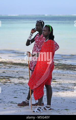 Due uomini Maasai permanente sulla spiaggia, spiaggia Kiwengwa, Zanzibar, Tanzania Foto Stock