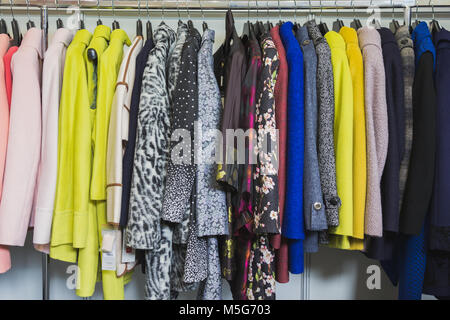 Abiti colorati in negozio di abbigliamento - abiti e giacche Foto Stock