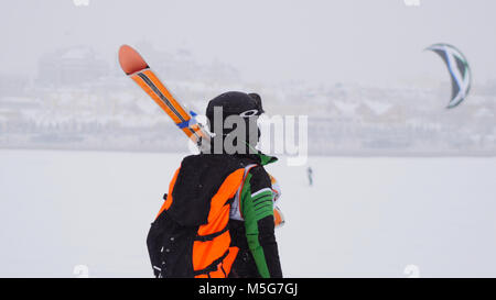 Kite surfer pronta per lo scorrimento. Snowkiting nella neve sul fiume congelato Foto Stock