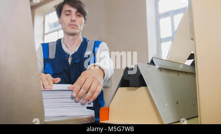 Processo di stampa - alimentazione di fogli di carta, industria poligrafo, close up Foto Stock