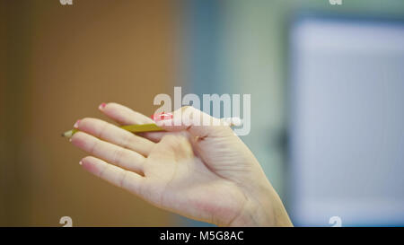 Gesti con le mani della donna Office Manager quando si parla al telefono - manicure con colore rosso brillante chiodi, close up Foto Stock