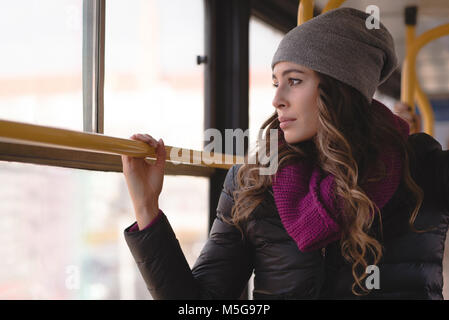 Donna che guarda attraverso la finestra mentre si viaggia in treno Foto Stock