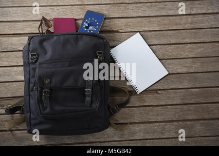 Immagine composita di vacanza sacco sul tavolato in legno e accessori su tavola in legno Foto Stock