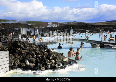 Ai visitatori di rilassarsi nel centro termale geotermica della Laguna Blu con Svartsengi centrale geotermica in background.vicino a Reykjavik.Islanda Foto Stock