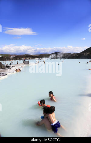 Ai visitatori di rilassarsi nel centro termale geotermica della Laguna Blu con Svartsengi centrale geotermica in background.vicino a Reykjavik.Islanda Foto Stock