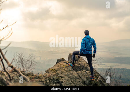 L'uomo celebrando o pregando in belle montagne ispiratrice sunrise. Escursionista silhouette sulla cima della montagna escursioni o scalate. Cerca e godendo inspira Foto Stock