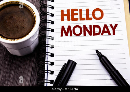 La scrittura di un testo che mostra Ciao lunedì. Il concetto di business per il giorno di inizio della settimana scritto sul libro dei notebook nota carta su legno sullo sfondo di legno. Con caffè e Foto Stock