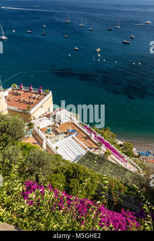 Positano incorniciato da rosa bouganville e barche in background. Colorato Positano, la perla della Costiera Amalfitana, con le sue case multicolori e Foto Stock