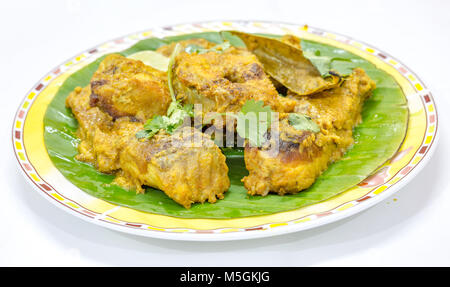 Gustosa Bengali Indian alimenti per pesci di masala Rohu pesce al curry servita su foglie di banana con il coriandolo e la fetta di limone. Foto Stock