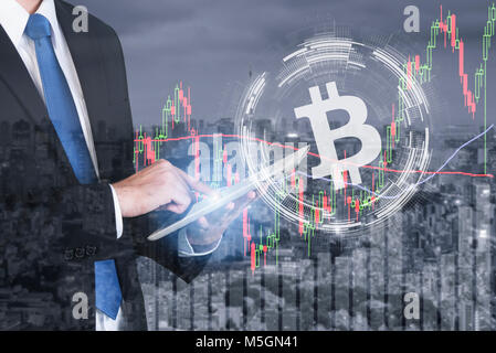 Imprenditore utilizzando il tablet bitcoin deal trading stock exchange di investimento sul mercato forex, con andamento del grafico, prezzo e candela stick grafico del magazzino c Foto Stock