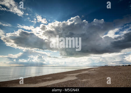 Giornata di sole con nuvole scure a Hayling Island seafront guardando verso l'Isola di Wight, Hampshire, Regno Unito Foto Stock