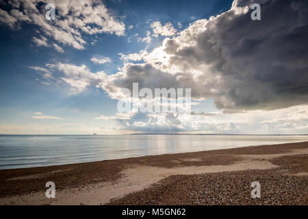 Giornata di sole con nuvole scure a Hayling Island seafront guardando verso l'Isola di Wight, Hampshire, Regno Unito Foto Stock