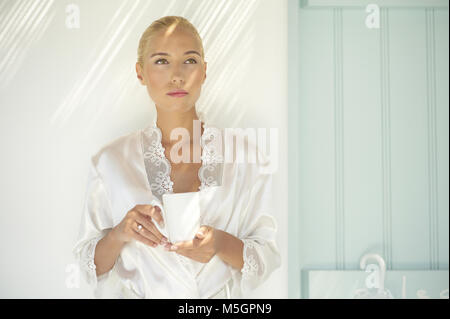 Bella donna bionda con tappo di caffè o di tè Foto Stock