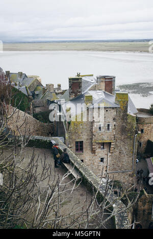 Case di Mont Saint Michel come visto dalla strada superiore accanto all'abbazia, monastero che si trova sulla parte superiore della piccola isola Foto Stock