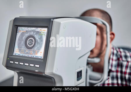 L'uomo controlla la sua visione sulla macchina Foto Stock