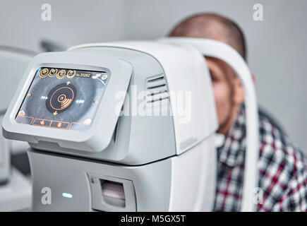 L'uomo controlla la sua visione sulla macchina Foto Stock
