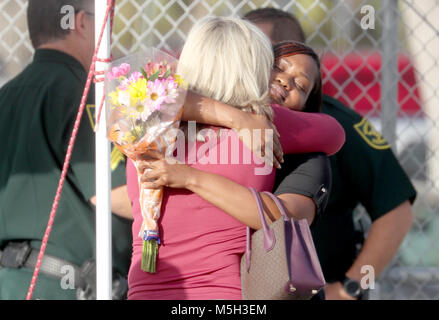 Coral Springs, in Florida, Stati Uniti d'America. 24 Febbraio, 2018. Assistant Principal DENISE REESE (torna alla telecamera) accoglie una scuola dipendente al suo ritorno a scuola. Gli insegnanti e gli amministratori scolastici restituito a Marjory Stoneman Douglas High School per un orientamento per la prima volta dopo 17 vittime sono state uccise in una massa di riprese a scuola. Credito: Mike Stocker/Sun-Sentinel/ZUMA filo/Alamy Live News Foto Stock