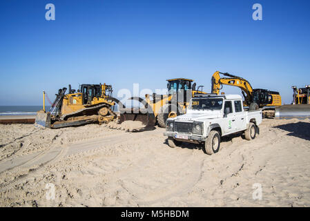 Rifornimento di sabbia / spiaggia nutrimento mediante dragaggio Internazionale / DEME con i bulldozer per ridurre i danni provocati dalla tempesta di strutture costiere in Belgio Foto Stock