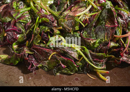 Amaranto Rosso, un tipo di spinaci popolare in asiatica, cotti in un wok Foto Stock