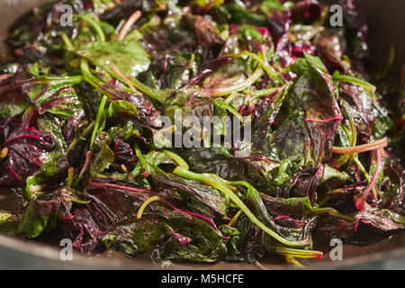 Amaranto Rosso, un tipo di spinaci popolare in asiatica, cotti in un wok Foto Stock