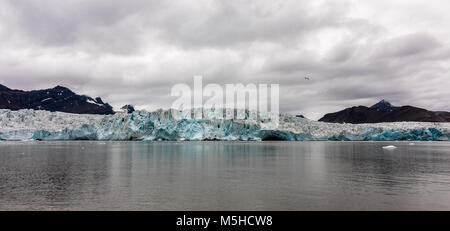 Incontro sul ghiacciaio l'Oceano artico. Ocean, ghiaccio e montagne con cielo nuvoloso sopra. Svalbard, Spitsbergen. Panorama Foto Stock