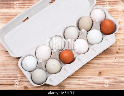 Non lavate fresche biologiche e ogm di soia pascolo libero sollevato le uova di gallina in una dozzina di cartone uovo su legno sfondo vintage Foto Stock