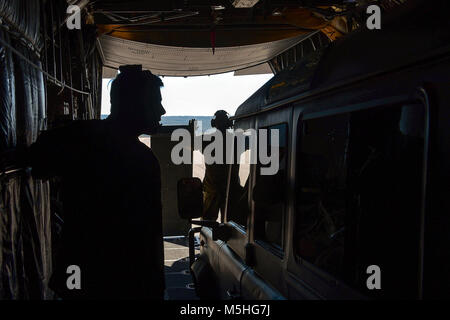 Airman 1. Classe Trevor Armentrout, 700 Airlift Squadron loadmaster, sinistra, colloqui con il conducente di un veicolo mentre Tech. Sgt. Michael Hoffman, 700 come loadmaster, prepara per abbassare una rampa durante un ponte aereo tattico missione in Portogallo, Febbraio 5, 2018. Il loadmasters lavorato con marina portoghese delle forze speciali nel veicolo per garantire che sono stati rapidamente scaricata come parte del disgelo reale 18, un portoghese-led esercizio che coinvolge diversi paesi della NATO che lavorano insieme per eseguire compiti realistici sia in aria e a terra. (U.S. Air Force Foto Stock