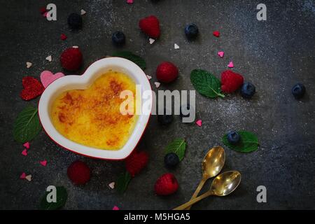 In casa classica francese Creme brulee on dark moody background / San Valentino di dessert Foto Stock