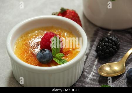 In casa Classic Creme brulee con zucchero bruciato berry topping, il fuoco selettivo Foto Stock