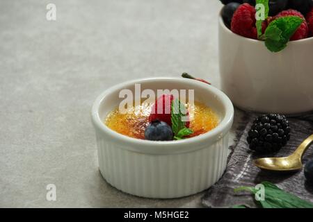 In casa Classic Creme brulee con zucchero bruciato berry topping, il fuoco selettivo Foto Stock