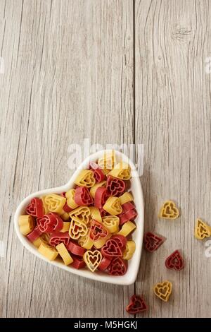 A forma di cuore in pasta un ramekin con copia spazio / San Valentino di sfondo Foto Stock