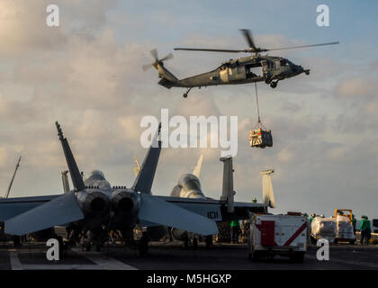 Sul mare del sud della Cina (feb. 10, 2018) un MH-60S Sea Hawk elicottero assegnato al "Cavalieri Neri" del mare in elicottero Combat Squadron (HSC) 4 offre un carico durante un rifornimento verticale in mare a bordo della Nimitz-class portaerei USS Carl Vinson (CVN 70). Carl Vinson Strike gruppo è attualmente operativo nel Pacifico occidentale come parte di una regolare distribuzione pianificata. (U.S. Navy Foto Stock