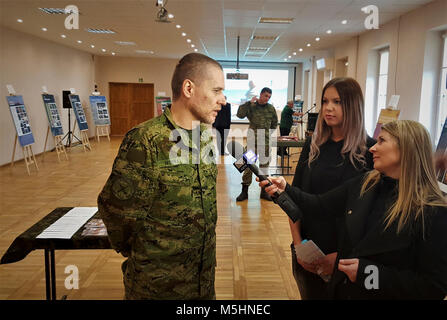 Esercito Croato Capt. Slaven Horvat, assegnato al vulcano croato batteria e Battle Group Polonia conduce un intervista con media polacco TVP3 spiegando i croati patrimonio culturale eventi, Sylwia Pindor (centro) serve come linguista durante il colloquio presso il polacco della XV Brigata meccanizzata sede Giżycko, Polonia, del 12 febbraio 2018. La celebrazione ha consentito l'ambasciatore per esprimere la mia gratitudine al leader polacco e condivisa cultura croata con il leader di comunità di presenze. L'unica, multinazionali del Battle Group è composto da Stati Uniti, Regno Unito, croato e soldati rumeni servire con th Foto Stock