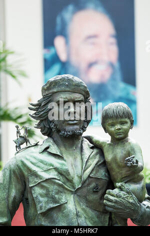 Santa Clara, Cuba - 10 dicembre 2017: monumento dell'eroe Ernesto Che Guevara con un bambino fra le braccia e sullo sfondo la immagine di Fidel Castr Foto Stock