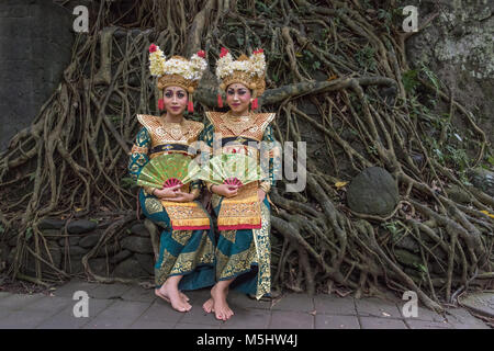 Coppia di ballerini Balinesi nei costumi tradizionali con radici di ficus in background, Monkey Forest, Ubud, Bali Foto Stock