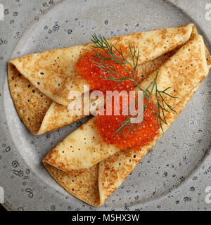 Il russo blinis con caviale rosso e aneto su una lastra grigia closeup Foto Stock