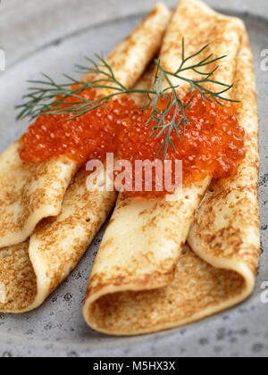 Il russo blinis con caviale rosso e aneto su una lastra grigia closeup Foto Stock