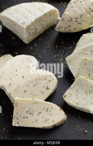 Estone di formaggi con cumino, aneto, e aglio su ardesia tagliere Foto Stock