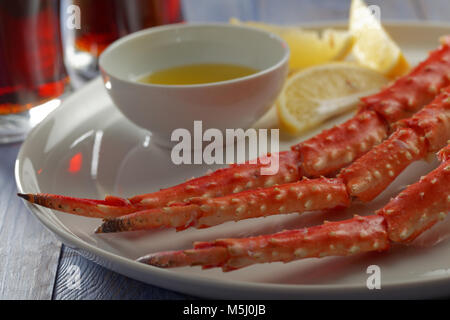 Red king crab gambe con limone e birra su di un tavolo rustico Foto Stock