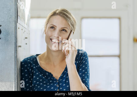 Ritratto di felice giovane donna al telefono Foto Stock