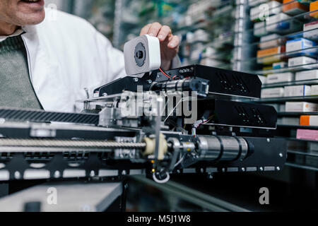 Il farmacista esaminando la messa in funzione la macchina in farmacia Foto Stock