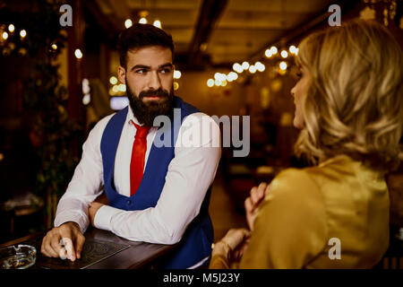 Moda giovane uomo che guarda la donna in un bar Foto Stock