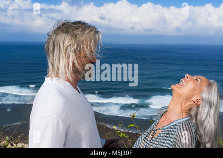 Ridendo coppia senior divertendosi al mare Foto Stock